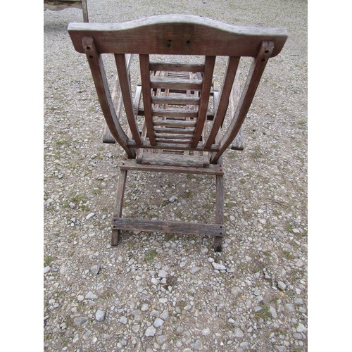 98 - Two weathered teak folding steamer type chairs with slatted seats, backs and foot rests, with brass ... 