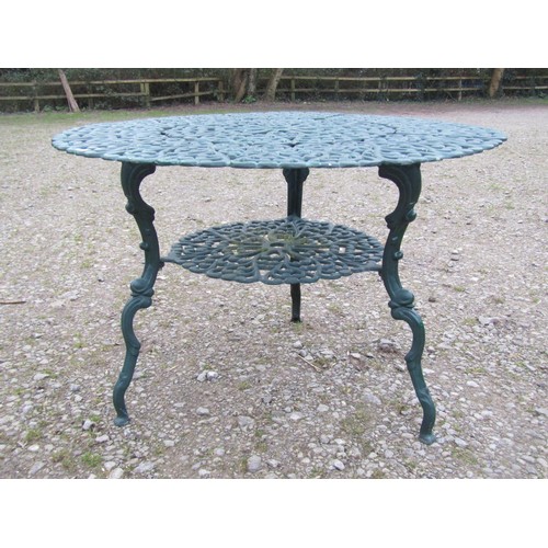 101 - A green painted cast alloy circular two tier garden terrace table, with decorative repeating 'c' scr... 