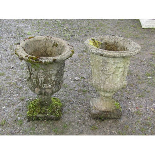 108 - A pair of weathered cast composition stone urns with flared rims and lobed bodies, and mythical proc... 