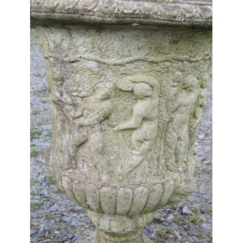 108 - A pair of weathered cast composition stone urns with flared rims and lobed bodies, and mythical proc... 