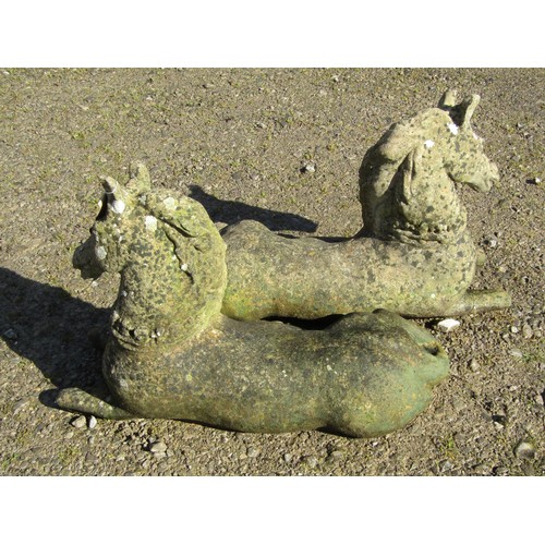 109 - A pair of weathered cast composition stone terrace or pier ornaments in the form of recumbent horses... 