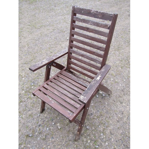 151 - A set of four stained and weathered contemporary folding hardwood garden armchairs with slatted seat... 