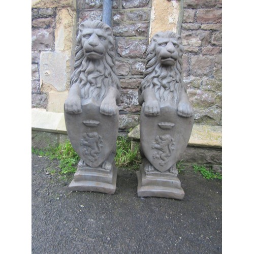 209 - A pair of cast composition stone pier/garden ornaments in the form of seated lions clutching armoria... 