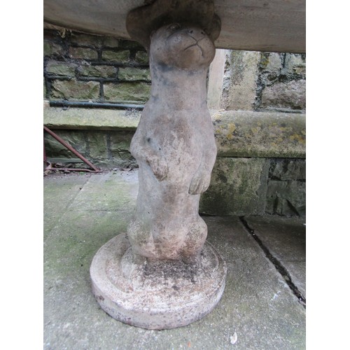 207 - A novelty weathered three sectional composition stone garden table with oval top on standing otter s... 