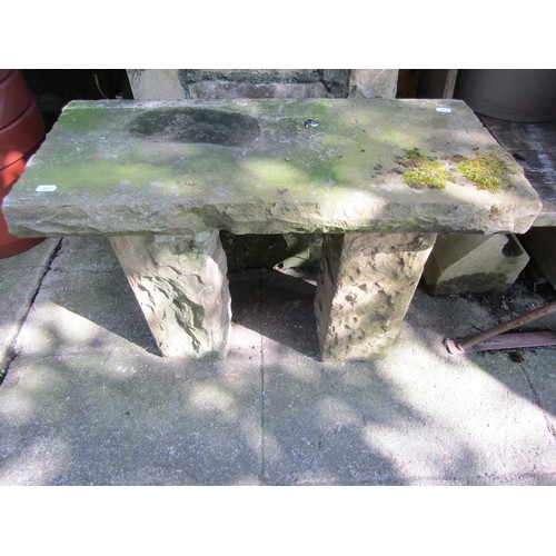 A weathered rough hewn stone garden bench with rectangular slab seat, raised on square cut supports, 52cm high x 72cm x 35cm