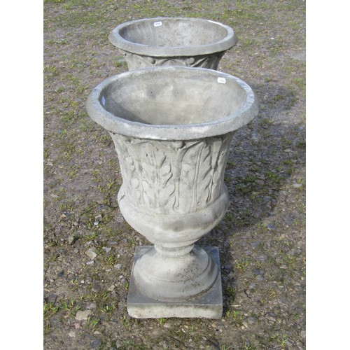 56 - A pair of composition stone trumpet shaped garden urns, with moulded acanthus detail, raised on step... 