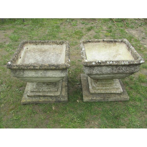 275 - A pair of weathered cast composition stone garden urns of squat square cut and tapered form with ros... 