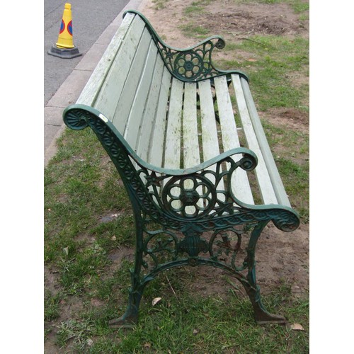 279 - A two seat garden bench with painted wooden slatted seat raised on decorative pierced cast iron end ... 