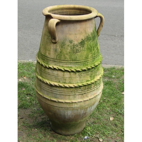 281 - A weathered terracotta olive jar of oviform with three moulded loop handles incised and moulded band... 