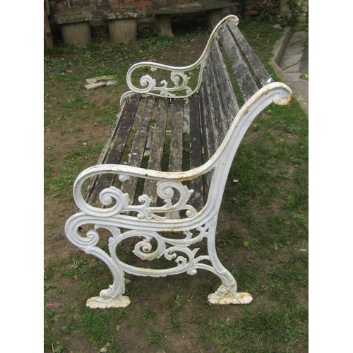 282 - A two seat garden bench with slatted seat and combined back raised on painted cast iron scroll patte... 