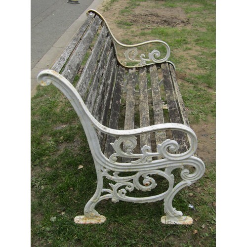 282 - A two seat garden bench with slatted seat and combined back raised on painted cast iron scroll patte... 