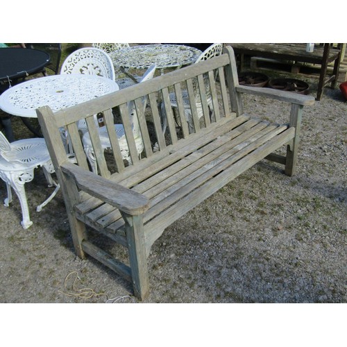 95 - A weathered teak garden bench with slatted seat and back, with traces of painted finish, 162cm long ... 