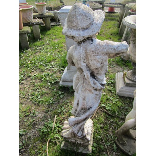 128 - A weathered cast composition stone garden statue in the form of a boy wearing a brimmed hat looking ... 