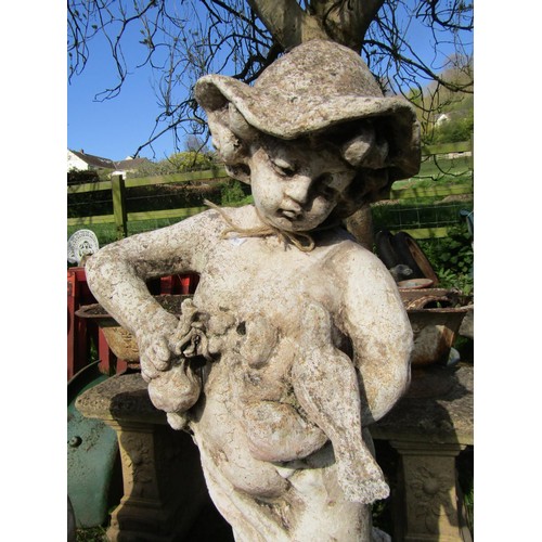 128 - A weathered cast composition stone garden statue in the form of a boy wearing a brimmed hat looking ... 