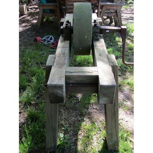 192 - A carved natural stone grinding wheel, 45cm diameter, set in a substantial weathered pine stand