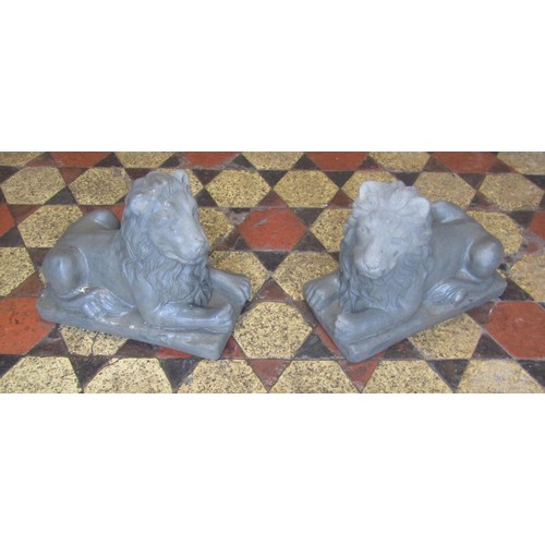 513 - A pair of cast composition stone recumbent lions 33 cm high x 40 cm long x 20 cm wide