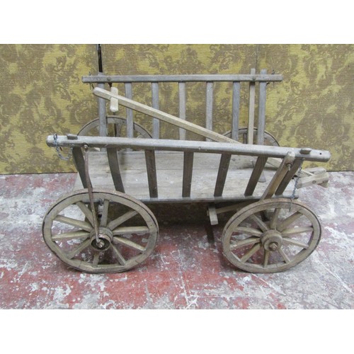 530 - An antique wooden hand cart with open slatted sides and four spoke wheels with iron rims