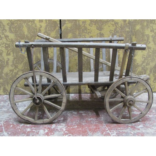 530 - An antique wooden hand cart with open slatted sides and four spoke wheels with iron rims