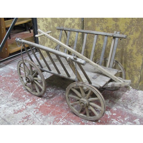 530 - An antique wooden hand cart with open slatted sides and four spoke wheels with iron rims