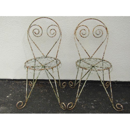 542 - A pair of weathered painted garden / patio chairs, with scrolling framework and wire work seats (2)