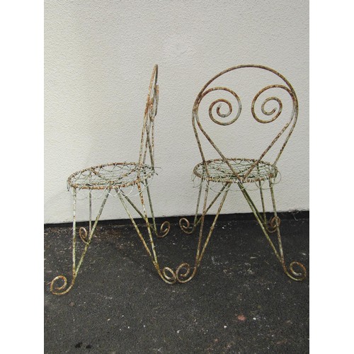 542 - A pair of weathered painted garden / patio chairs, with scrolling framework and wire work seats (2)