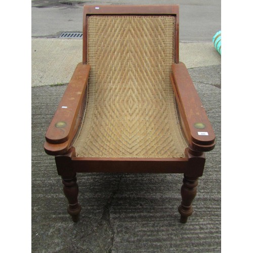 543 - An early 20th century teak plantation chair, with curved woven rattan seat and folding / extending a... 