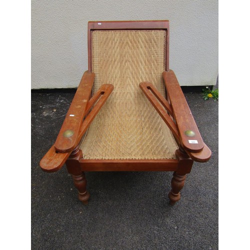 543 - An early 20th century teak plantation chair, with curved woven rattan seat and folding / extending a... 