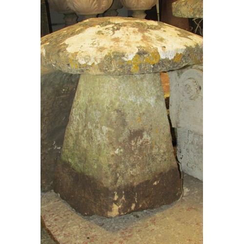 507 - A weathered carved natural stone staddle stone and associated cap, 70cm high, 60cm diameter.