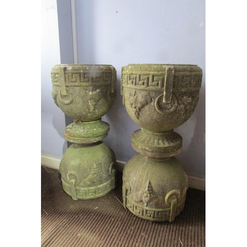 A matched set of four weathered composition stone planters, of pedestal urn form with moulded Greek key and fruiting vine motifs, 39cm high, 35cm diameter (4)