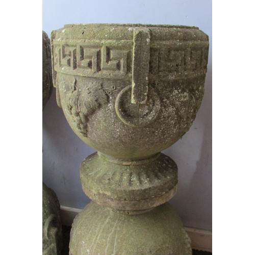 533 - A matched set of four weathered composition stone planters, of pedestal urn form with moulded Greek ... 