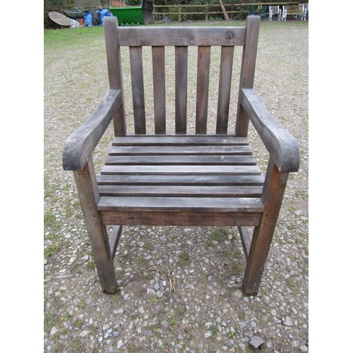 73A - A weathered circular teak table and four associated armchairs (5)