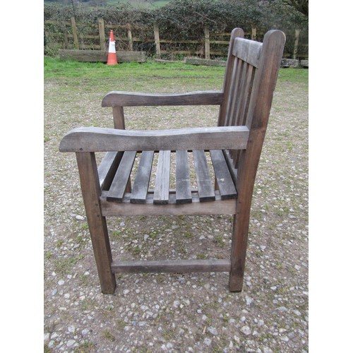 73A - A weathered circular teak table and four associated armchairs (5)