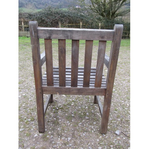 73A - A weathered circular teak table and four associated armchairs (5)