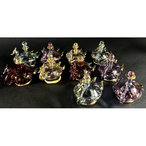 89 - Ten iridescent gilded blown glass  swan perfume bottles, together with a pink flamingo perfume bottl... 