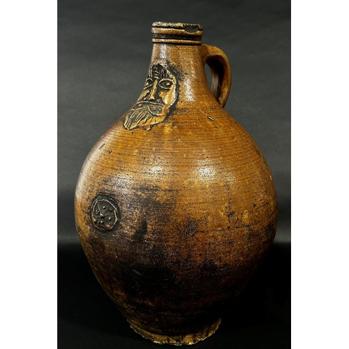 65 - A stoneware Bellarmine with moulded face and symbol, 37cm high