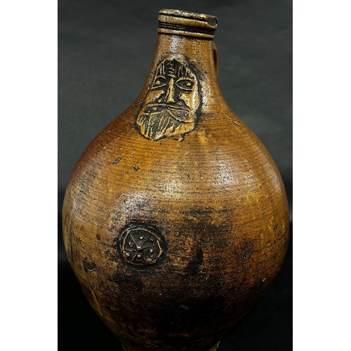 65 - A stoneware Bellarmine with moulded face and symbol, 37cm high