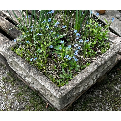 139 - A shallow weathered cast composition stone garden trough of square form with fruiting swag and lions... 