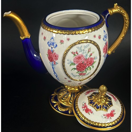 41 - A porcelain coffee pot - the Faberge egg imperial teapot, the ivory coloured body within a blue and ... 