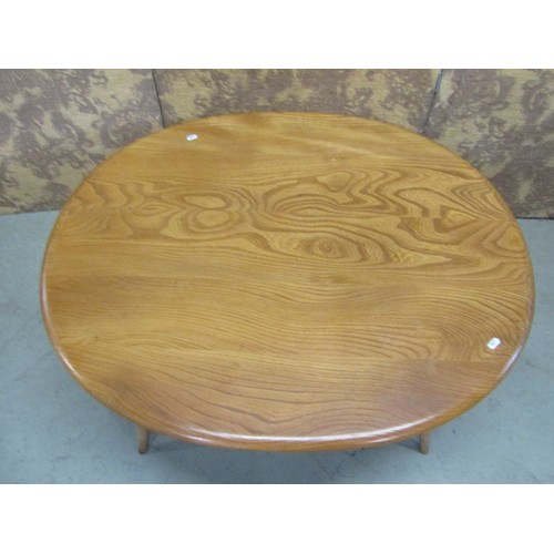 1117 - An Ercol occasional table of oval form, on turned supports with under gallery, with well figured elm... 