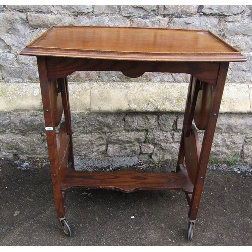 1123 - A patent oak tea trolley with folding cake racks, together with a pegged oak occasional table