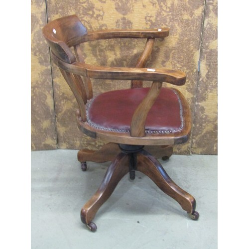 1221 - An Edwardian beechwood office chair with upholstered seat on a revolving base