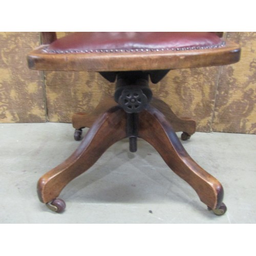 1221 - An Edwardian beechwood office chair with upholstered seat on a revolving base