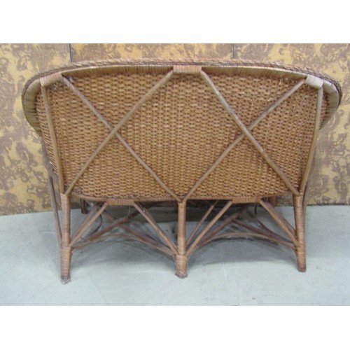 1243 - A vintage wicker two seat sofa, a mid century wicker plate glass occasional table of circular form a... 