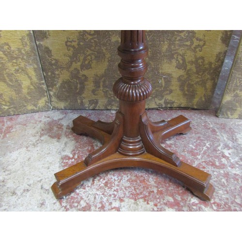 1213 - A late 19th century mahogany occasional table the oval top raised on a reeded tapering column and pl... 