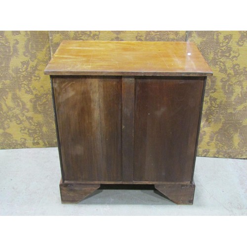 1165 - A Regency mahogany bedside cabinet enclosed by cupboard doors and drawers with lion mask and ring ha... 