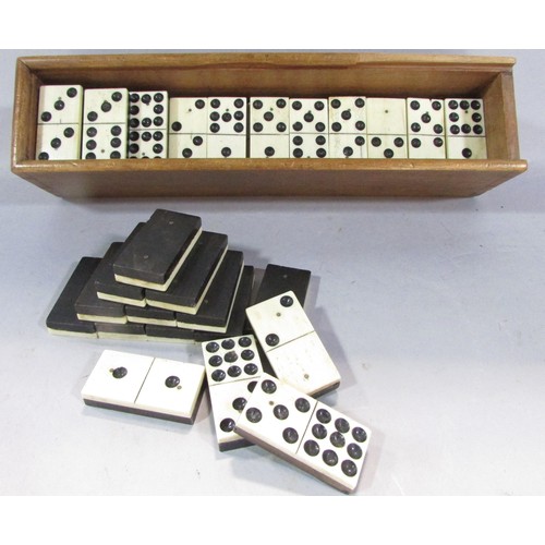 566 - An Antique Nine Dot Domino set in a wooden case, only 53 tiles, a set of wooden draughts counters, a... 