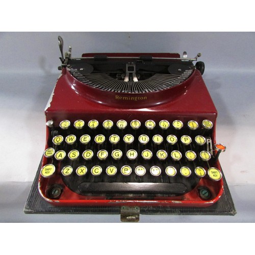 568 - A Remington red painted “World Service” portable typewriter Serial number V.195039, in its  carry ca... 