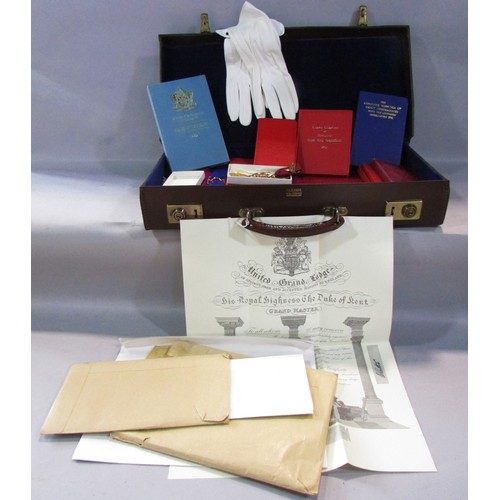 571 - A Masonic lodge case containing aprons, books on regulations, investitures and constitutions,  a pai... 