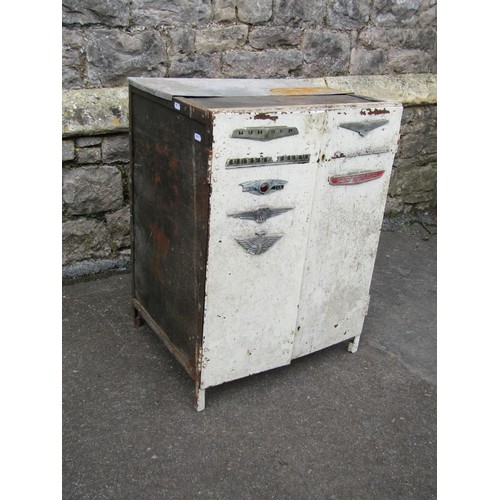 1028 - A vintage heavy gauge industrial painted steel two door cabinet with applied car badges to include H... 