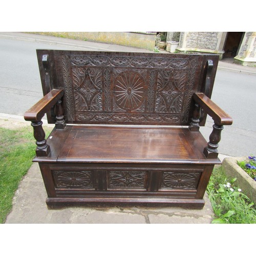 1346 - A late 19th century oak monks bench with geometric carved panels on turned supports, with rising/adj... 